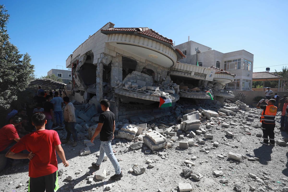 Palestinos inspecionam os destroços de um prédio depois que as forças israelenses demoliram a casa de dois andares do prisioneiro palestino Muntasir Shelbi, de 44 anos, onde morava sua família, na cidade de Turmusaya de Ramallah, Cisjordânia, em 8 de julho de 2021 [İssam Rimawi/Agência Anadolu]
