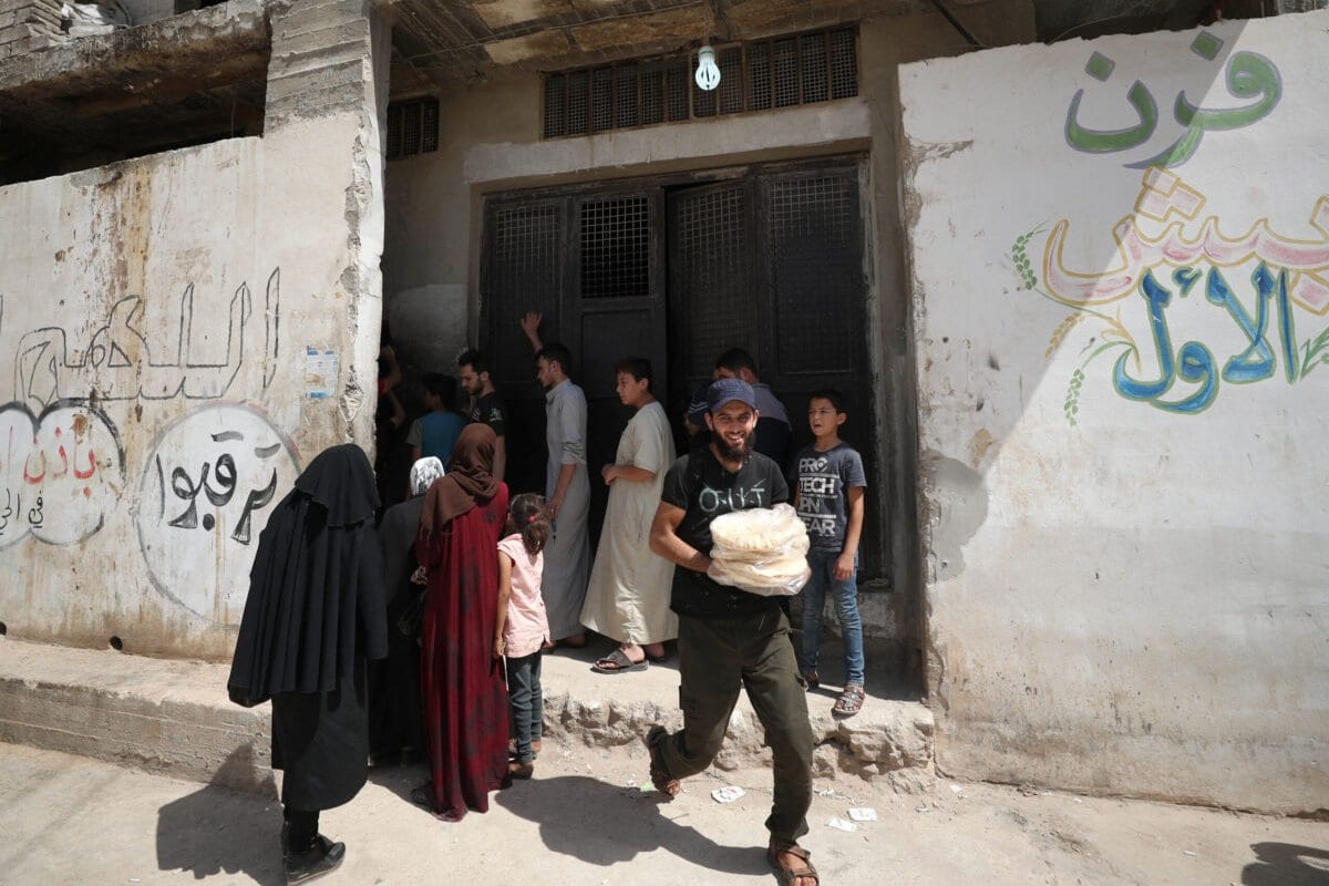 Sírios fazem fila para comprar pão na cidade de Binnish, na província de Idlib, noroeste do país, em 9 de junho de 2020 [Omar Haj Kadour/AFP via Getty Images]

