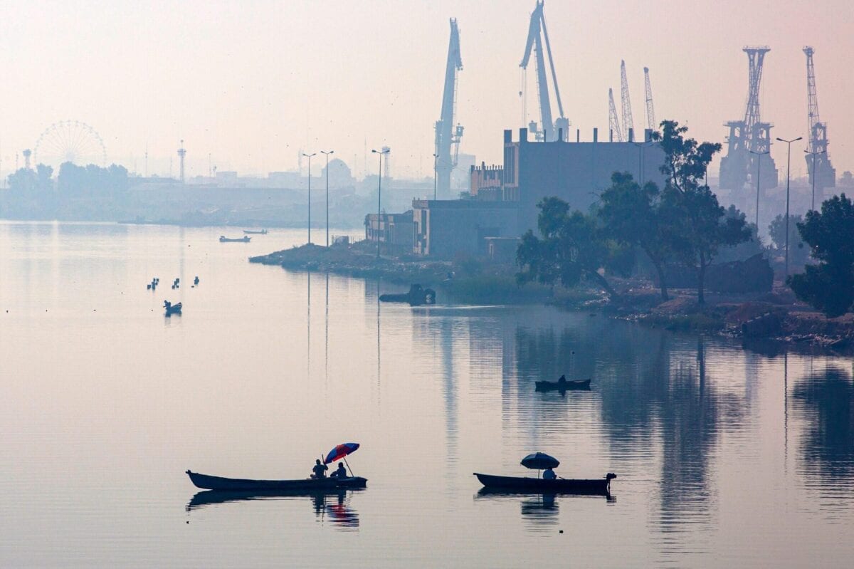 Pescadores no principal porto de Maqil, na cidade iraquiana de Basra,  sul do Iraque, com vista para o rio Shatt al-Arab, formado pela confluência do Eufrates e do Tigre, em 3 de novembro de 2020 [HUSSEIN FALEH/AFP via Getty Images].
