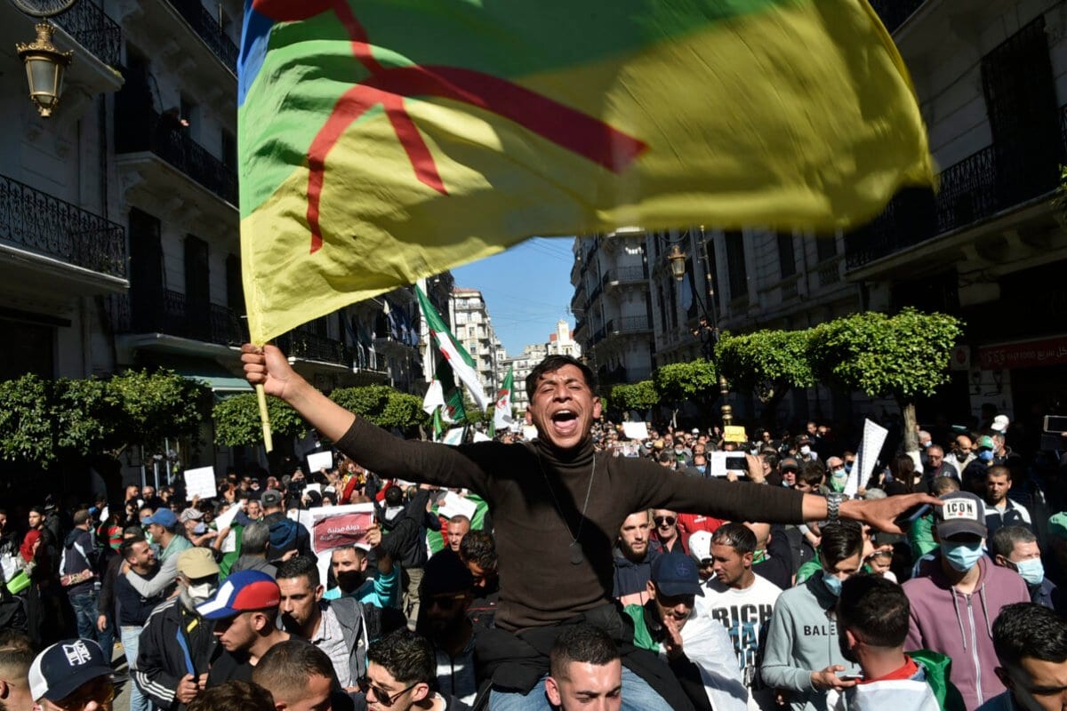 Manifestante exibe uma bandeira berbere durante um ato contra o governo em Argel, capital da Argélia, em 12 de março de 2021 [Ryad Kramdi/AFP via Getty Images]
