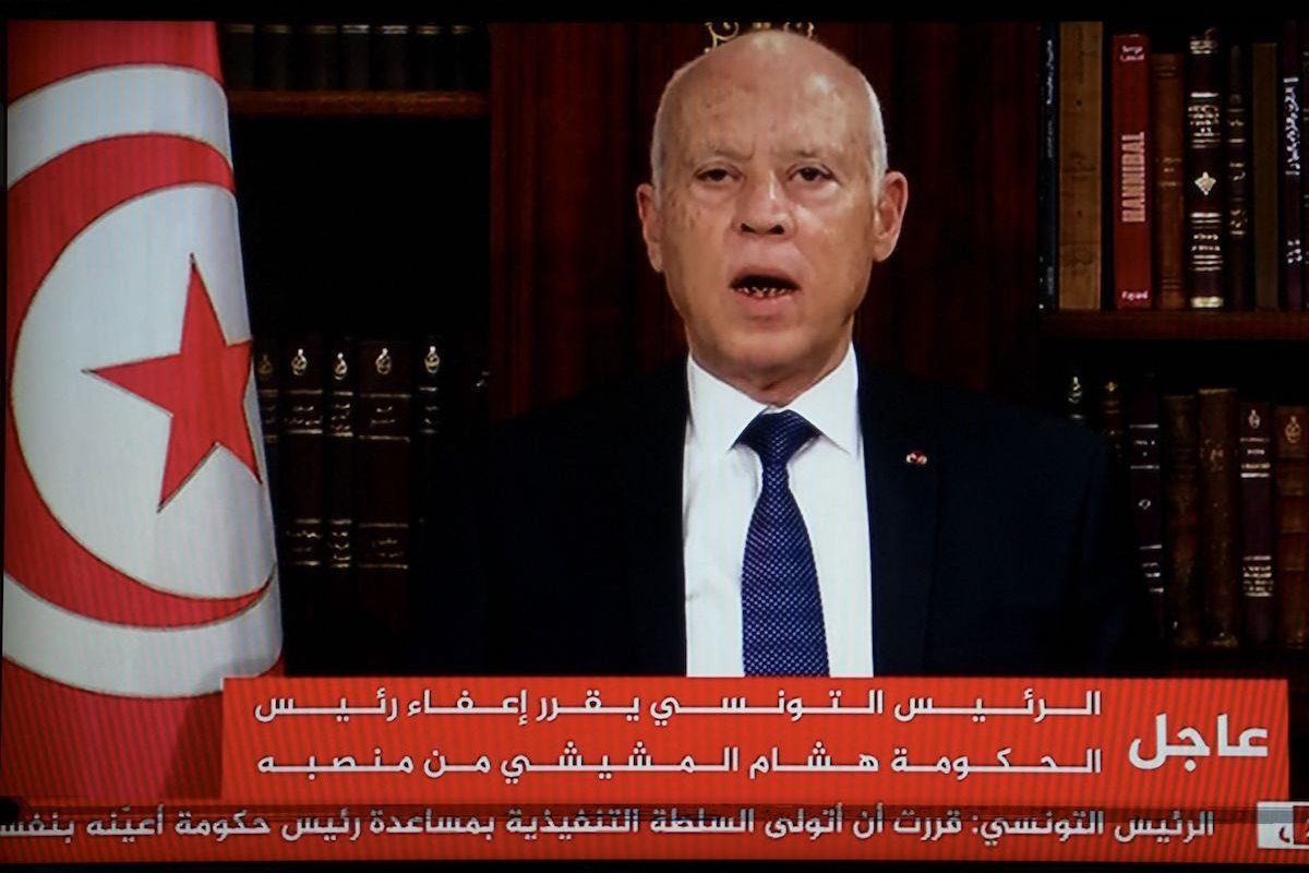 Canal de televisão tunisiano transmite o Presidente Saied anunciando a dissolução do Parlamento e demissão do primeiro-ministro Mechichi, em 25 de julho de 2021, no Palácio de Cartago, após um dia de protesto em todo o país [FETHI BELAID/AFP via Getty Images]
