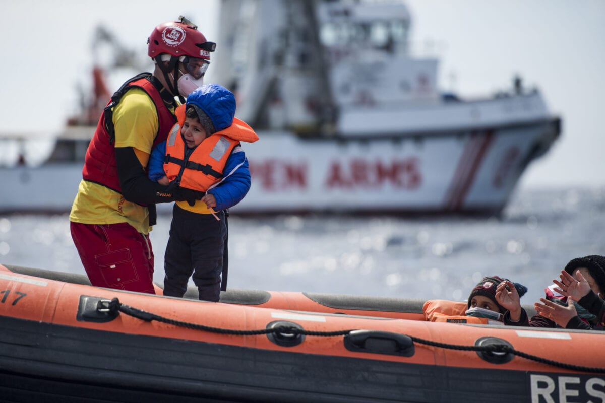 Um salva-vidas da ONG espanhola Open Arms segura uma criança após tirá-la de um barco de madeira em que 38 migrantes de diferentes nacionalidades, a maioria líbios, tentavam atravessar para a Europa, em 27 de março de 2021 [Carlos Gil Andreu/Getty Images]
