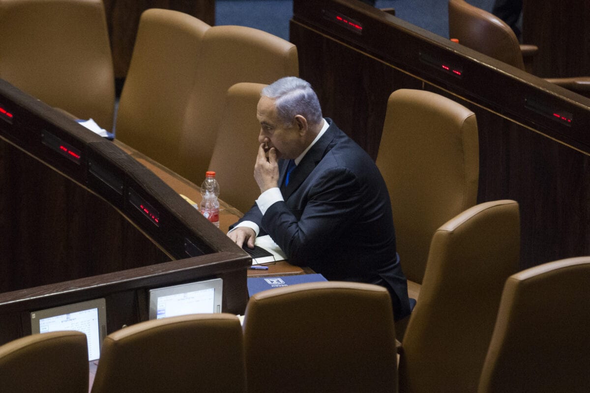 Ex-primeiro-ministro israelense, Benjamin Netanyahu, sentado no Knesset antes da votação do parlamento para aprovar o novo governo, em 13 de junho de 2021, em Jerusalém [Amir Levy/Getty Images]
