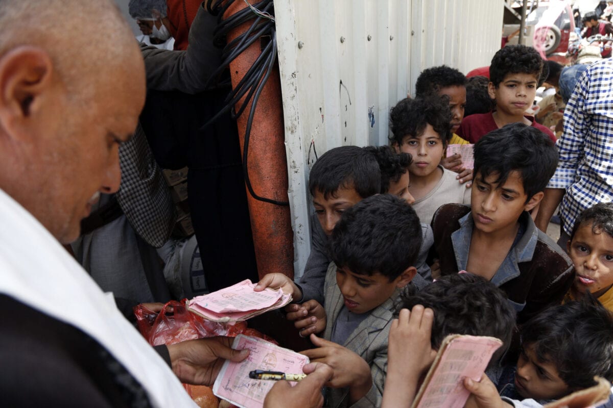 Voluntário checa documentos de crianças afetadas pela guerra para lhes conceder refeições gratuitas, na área de Mseek, em Sanaa, Iêmen, 29 de junho de 2021 [Mohammed Hamoud/Getty Images]
