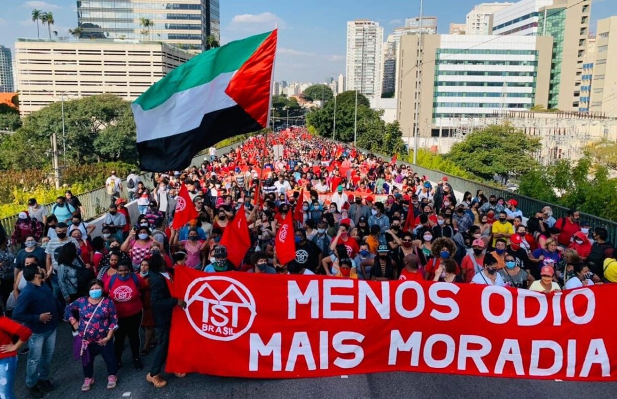 Manifestantes levantam bandeira palestina em protesto por moradia na cidade de São Paulo, em 08 de julho de 2021 [ Foto: MTST]