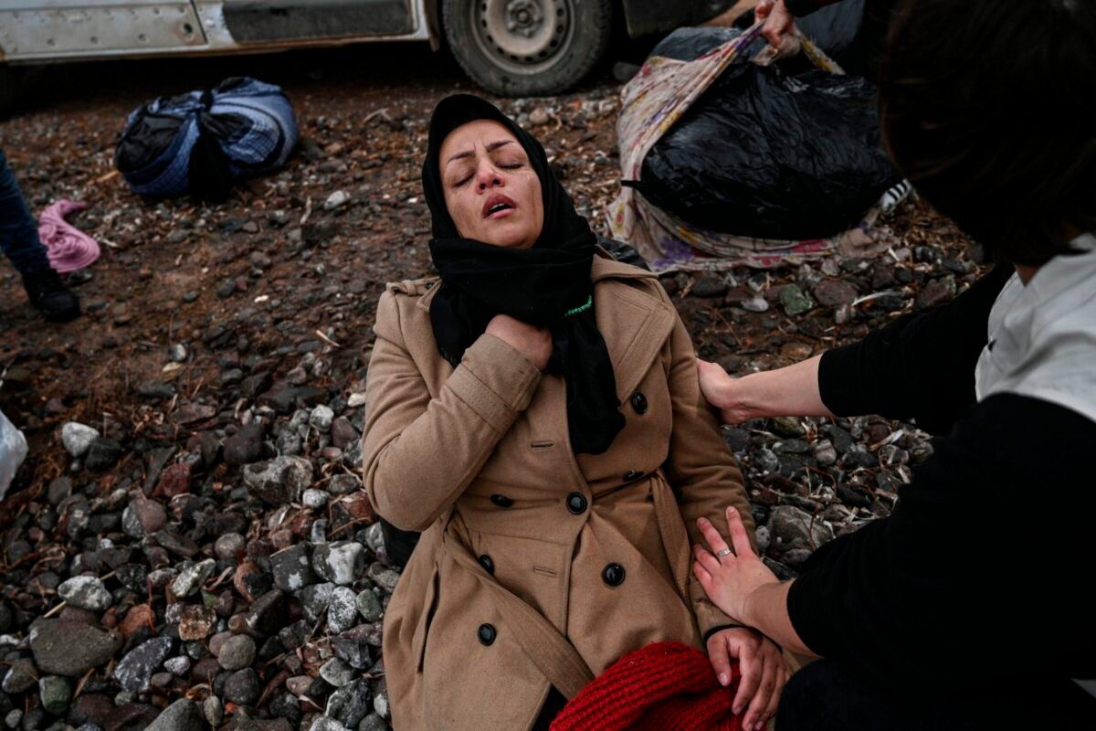 Mulher reage à chegada de um bote improvisado com 54 refugiados afegãos na ilha de Lesbos, Grécia, 28 de fevereiro de 2020 [Aris Messinis/AFP via Getty Images]