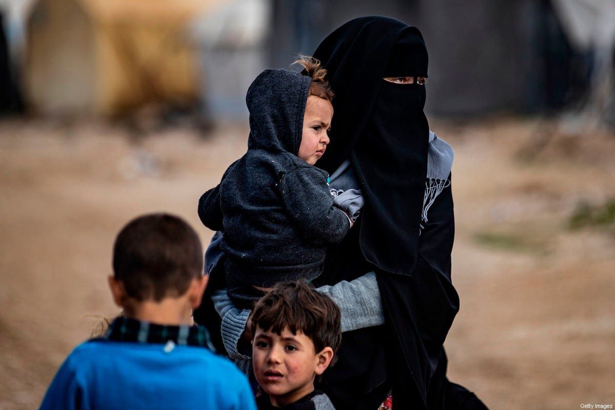 Mulheres e crianças são fotografadas no campo de al-Hol administrado pelos curdos, que mantém parentes suspeitos de combatentes do Daesh, na governadoria de Hasakeh, no nordeste da Síria, em 17 de fevereiro de 2021 [Delil Souleiman/AFP via Getty Images]

