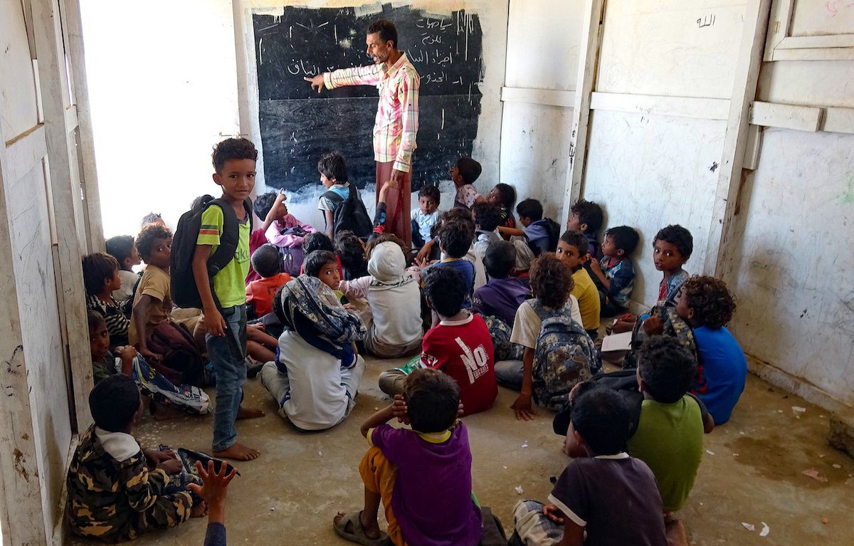 Meninos iemenitas deslocados assistem aula em uma escola improvisada por voluntários, na província de Hodeidah, assolada pela guerra, em 14 de março de 2021 [KHALED ZIAD/AFP via Getty Images]
