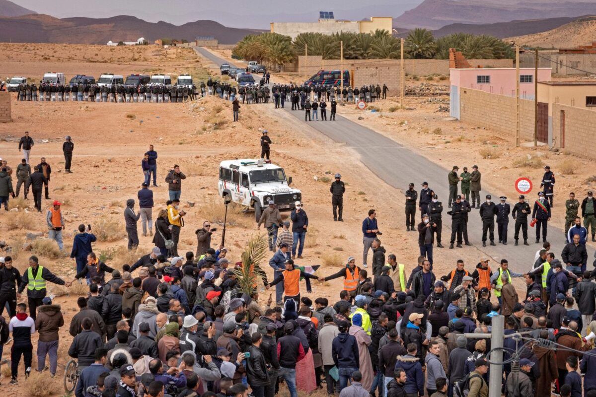 Forças de segurança marroquinas ficam de guarda enquanto fazendeiros marroquinos protestam na cidade fronteiriça de Figuig, em 18 de março de 2021 [Fadel Senna/AFP via Getty Images]
