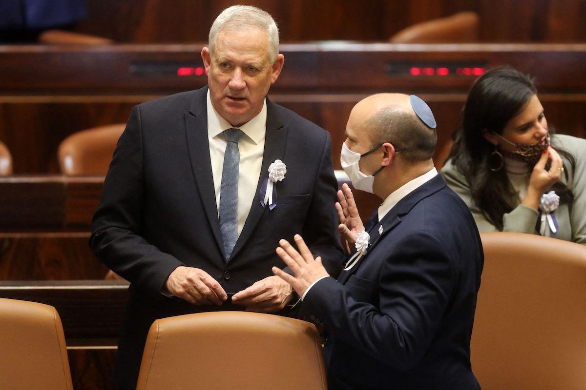 O ministro da Defesa de Israel, Benny Gantz (esq.) e o primeiro-ministro, Naftali Bennett, falam um com o outro em uma reunião do Knesset (parlamento) durante a qual Isaac Herzog, um veterano do Partido Trabalhista de esquerda de Israel, foi empossado como 11º presidente do estado judeu, substituindo Reuvin Rivlin, em Jerusalém, em 7 de julho de 2020 [Gil Cohen-Magen/AFP via Getty Images]
