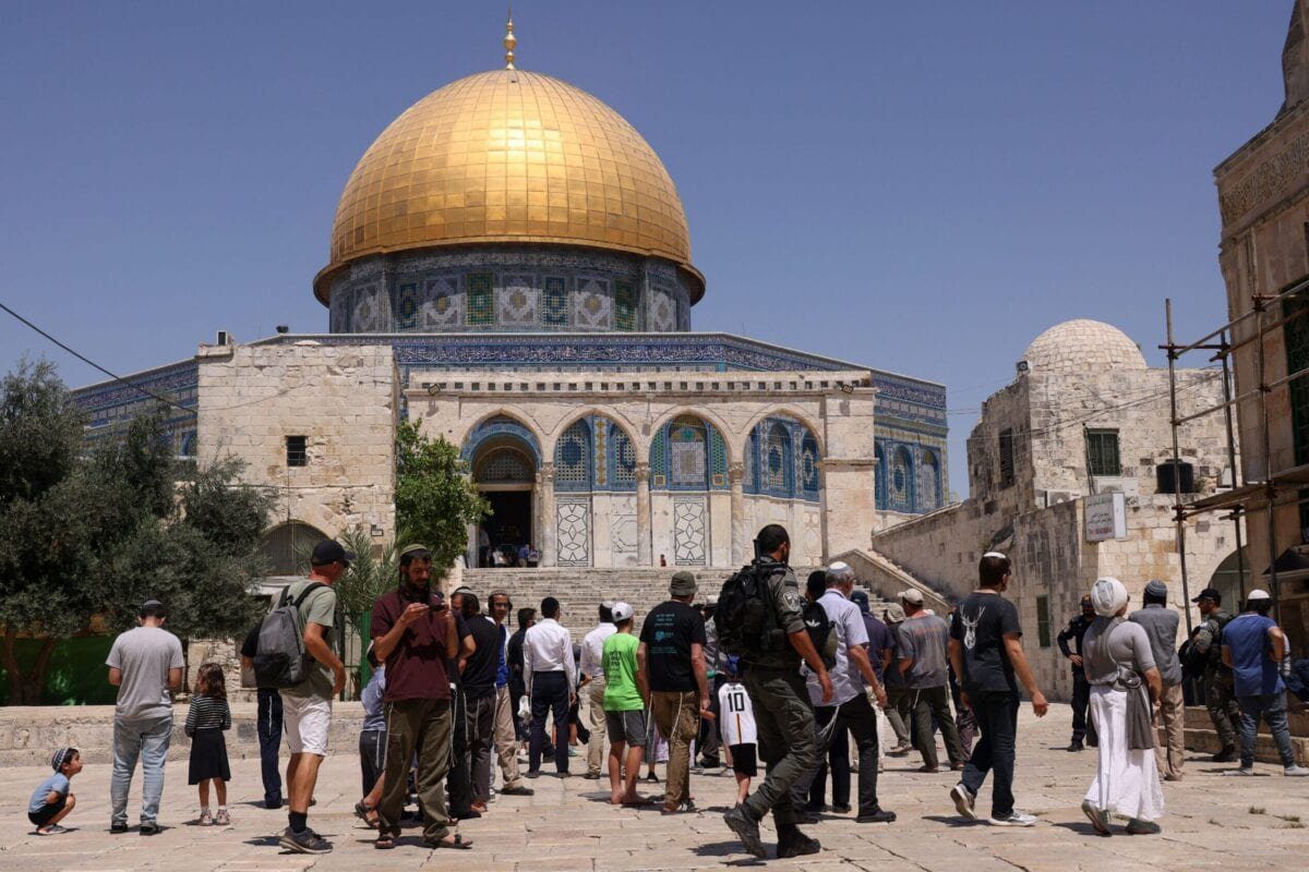Membros das forças de segurança israelenses ficam de guarda, enquanto um grupo de judeus ortodoxos entra no complexo da mesquita de al-Aqsa em Jerusalém [Ahmad Gharabli/AFP via Getty Images]
