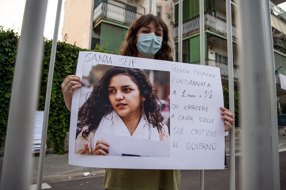 Uma mulher mostra uma fotografia de Sanaa Seif durante uma manifestação em solidariedade a Patrick Zaki e ativistas de direitos humanos detidos em todo o mundo, em 16 de junho de 2021, em Nápoles, Itália [Ivan Romano/Getty Images]
