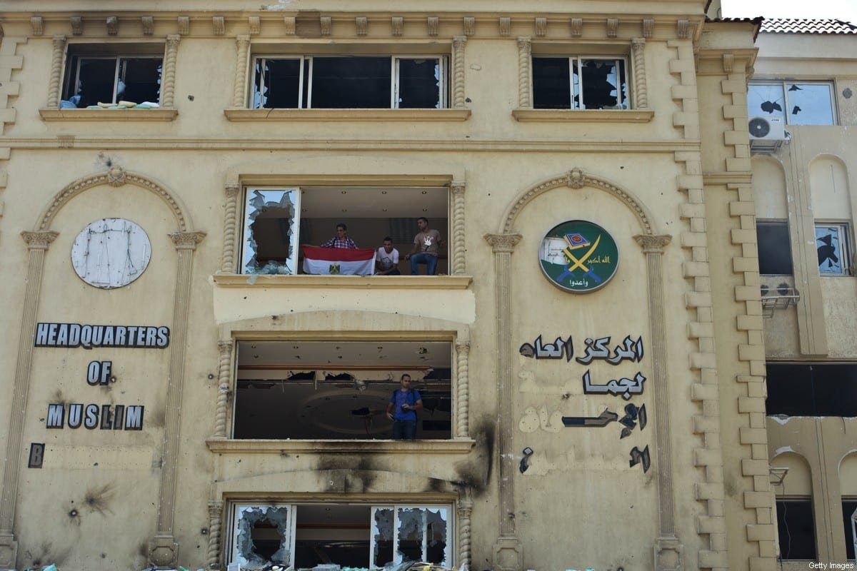 Manifestantes egípcios na sede incendiada da Irmandade Muçulmana, no distrito de Moqattam, Cairo, em 1º de julho de 2013 [KHALED DESOUKI/AFP via Getty Images]