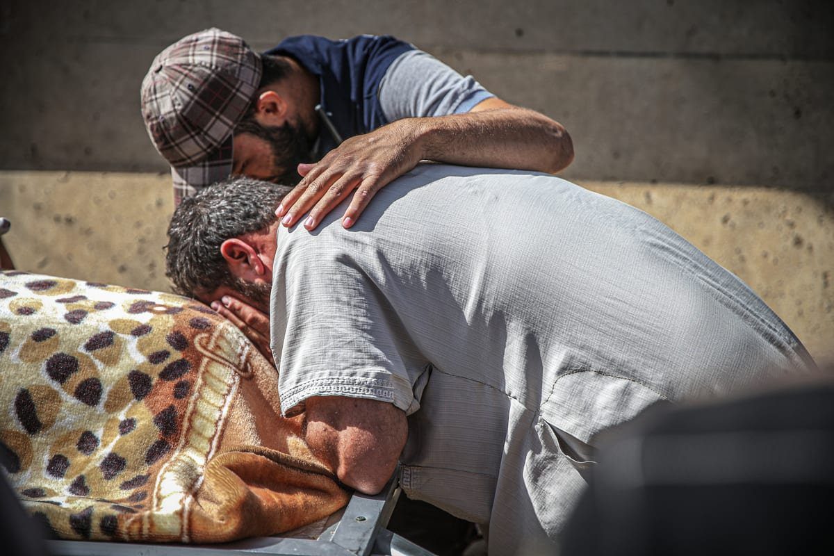 Parentes choram durante um funeral realizado por crianças sírias que foram mortas por Bashar Al-Assad em Idlib, Síria, em 3 de julho de 2021 [Muhammed Said/Agência Anadolu]
