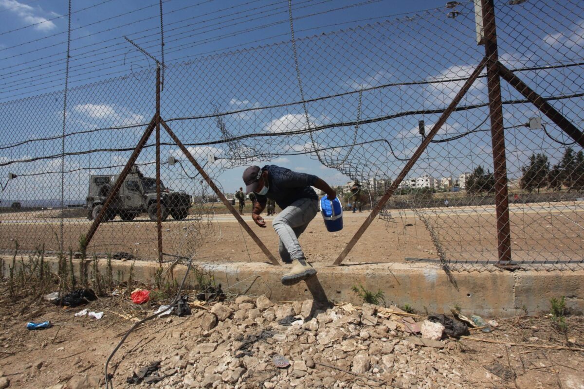 Trabalhadores palestinos residentes na Cisjordânia, trabalhando em Israel, passaram pela área aberta da cerca, porque as passagens foram fechadas, em 06 de setembro de 2021, em Jenin, Cisjordânia [Nedal Eshtaya/Agência Anadolu]