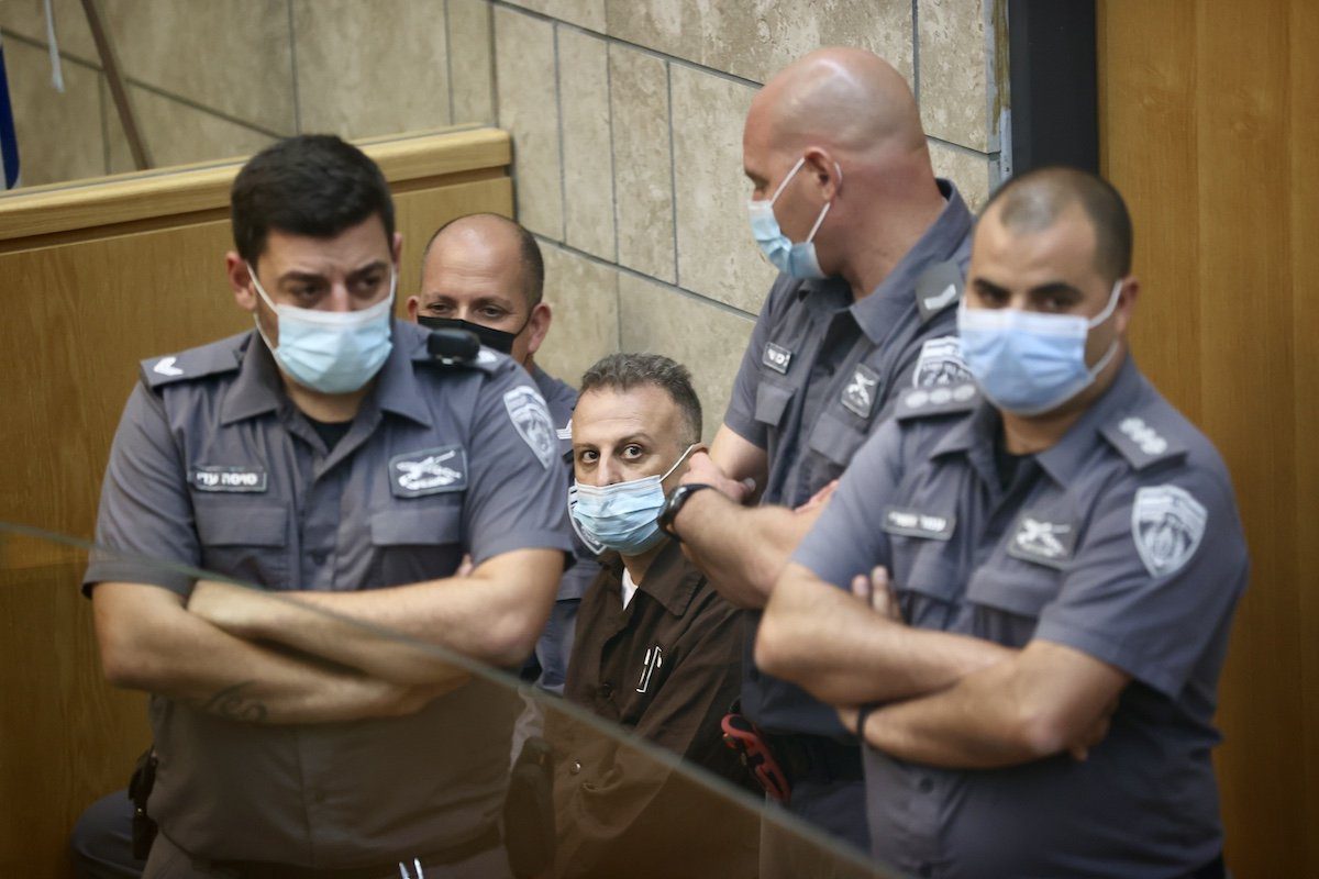 Yaqoub Qadri, um dos seis palestinos que escaparam da prisão de segurança máxima de Gilboa, cercado por policiais israelenses durante julgamento na corte de Nazaré, após ser recapturado, em 11 de setembro de 2021 [Mostafa Alkharouf/Agência Anadolu]
