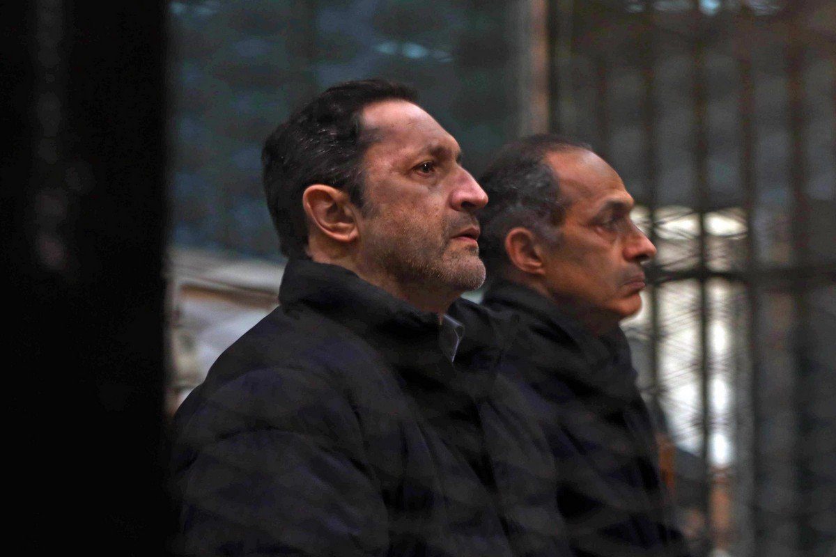 Alaa e Gamal Mubarak, filhos do ex-presidente egípcio Hosni Mubarak, sentam-se dentro da prisão dos réus no tribunal da Academia de Polícia do Cairo, em 22 de fevereiro de 2020 [AFP/Getty Images]
