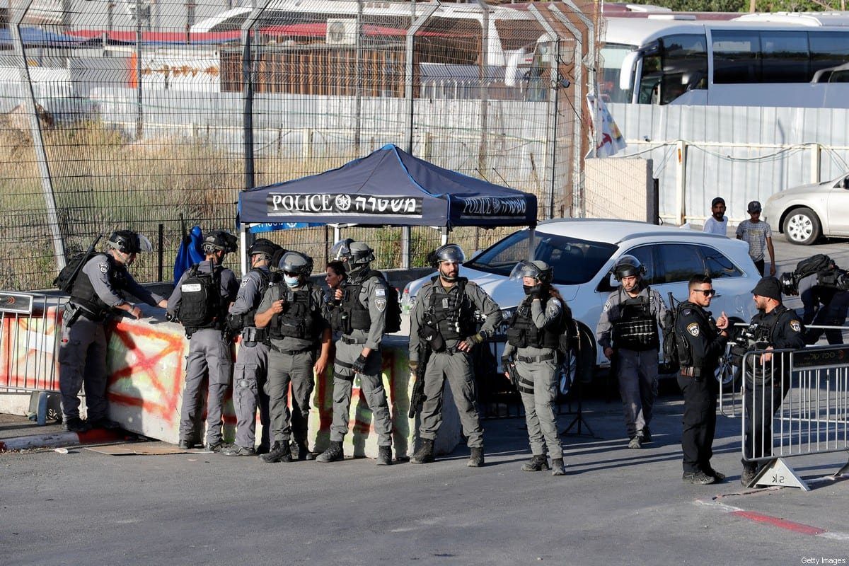 Forças de segurança israelenses ficam de guarda para evitar que palestinos passem por um posto de controle israelense na entrada do bairro Sheikh Jarrah, em Jerusalém Oriental, durante um protesto de manifestantes exigindo a reabertura do bloqueio, em 29 de maio de 2021 [Ahmad Gharabli/AFP via Getty Imagens]
