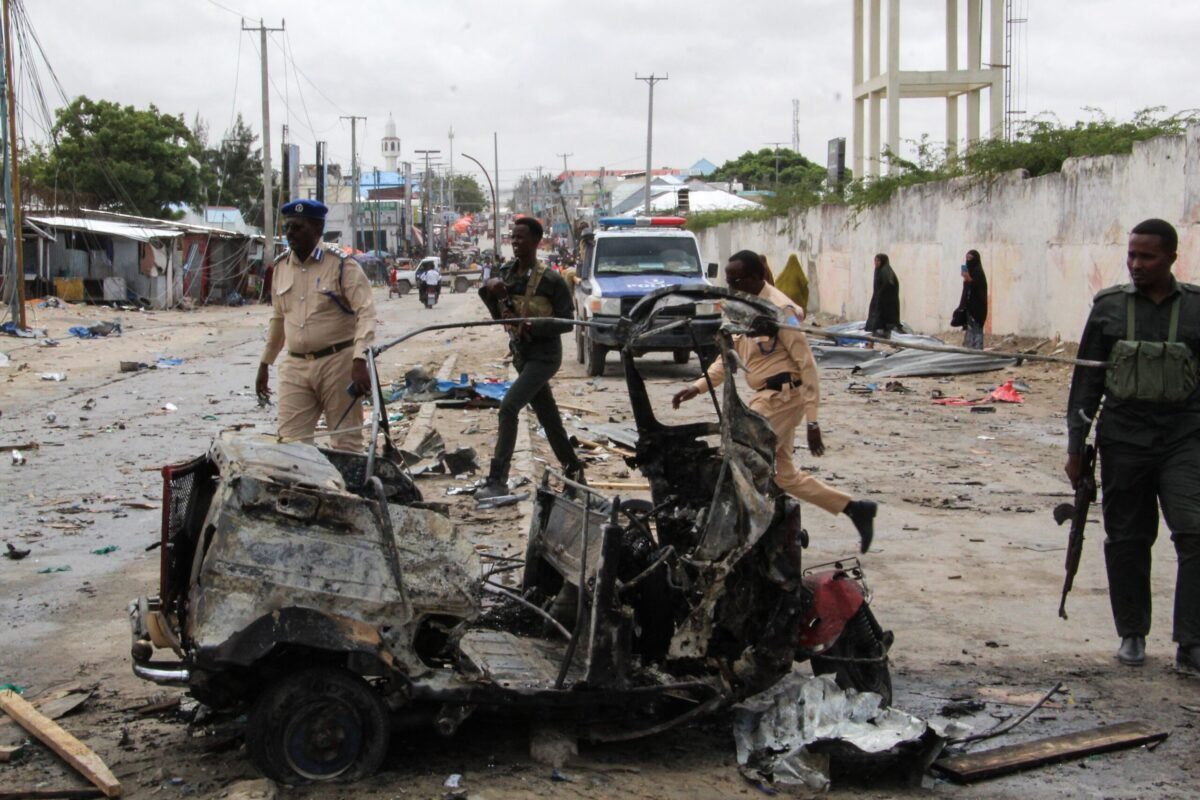 Policiais patrulham os destroços de um carro na cena do ataque suicida com carro-bomba que teve como alvo o comissário de polícia da cidade em Mogadíscio, em 10 de julho de 2021 [AFP via Getty Images]
