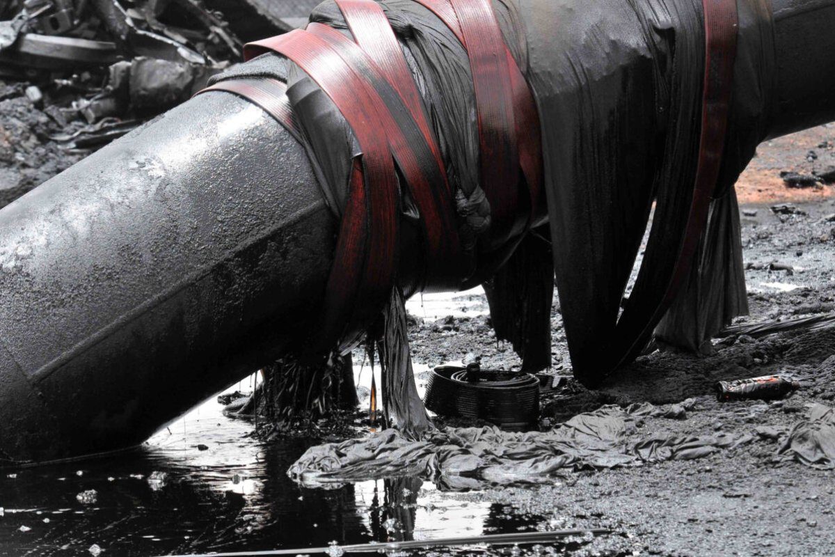 Vazamentos de óleo de um tubo em uma instalação de processamento queimada no principal centro de petróleo do Sudão, Heglig, na fronteira com o Sudão do Sul em 24 de abril de 2012 [Ebrahim Hamid/AFP via Getty Images]
