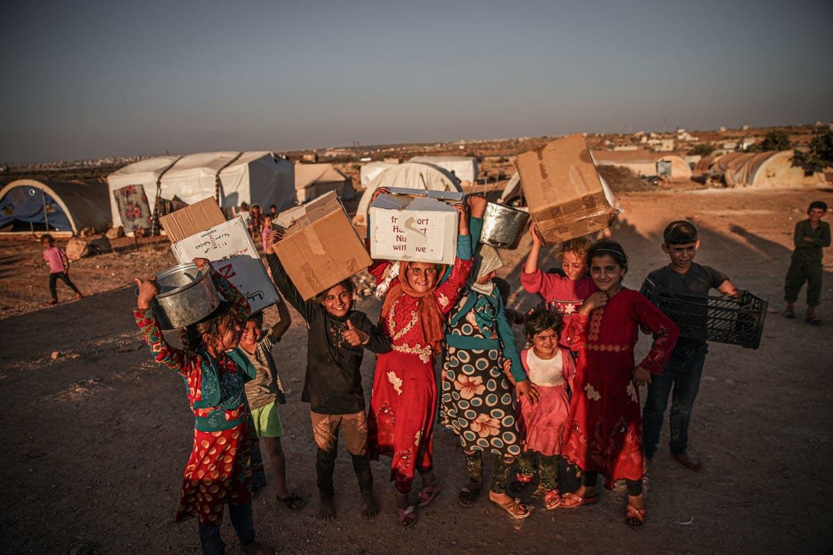 Sírios que se abrigam em um campo aguardam ajuda enquanto exigem que a passagem de fronteira de Bab Al-Hawa permaneça aberta para receber qualquer ajuda humanitária em Idlib, Síria, em 30 de junho de 2021 [Muhammed Said/Agência Anadolu]
