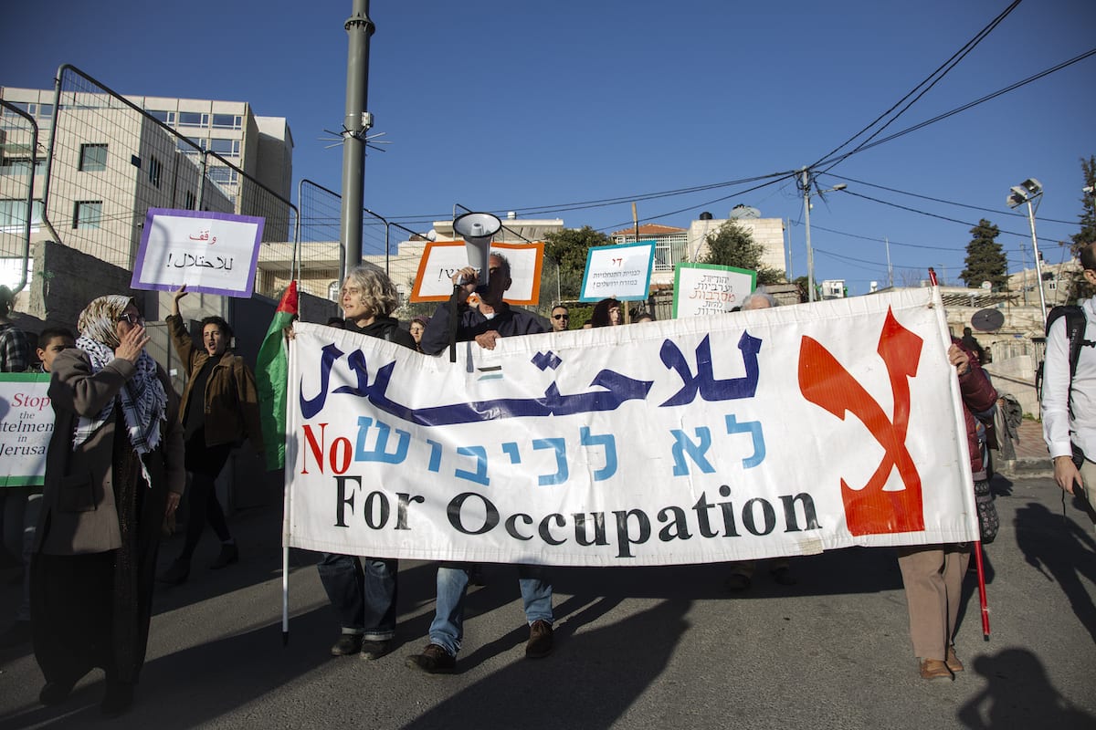 Ativistas de paz israelenses e estrangeiros fazem um protesto contra a decisão das autoridades israelenses de evacuar famílias palestinas que vivem no bairro de Sheikh Jarrah, em Jerusalém Oriental, em 25 de janeiro de 2019 [Faiz Abu Rmeleh/Agência Anadolu]
