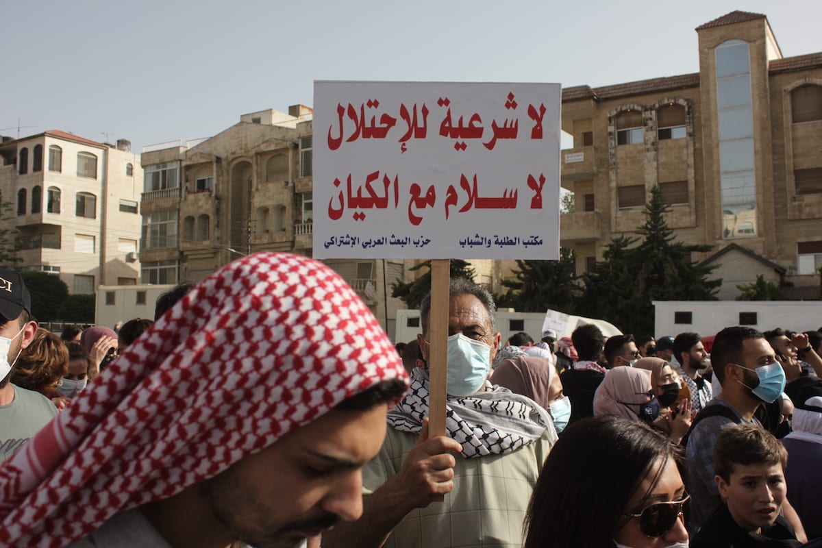 Jordanianos e palestinos seguram faixas durante uma manifestação exigindo que o governo demitisse o embaixador israelense do país durante um protesto contra os ataques da polícia israelense com gás lacrimogêneo, balas de borracha e granadas de choque contra palestinos em Masjid al-Aqsa, em 10 de maio de 2021, em Amã, Jordânia [Laith Al-jnaidi/Agência Anadolu]
