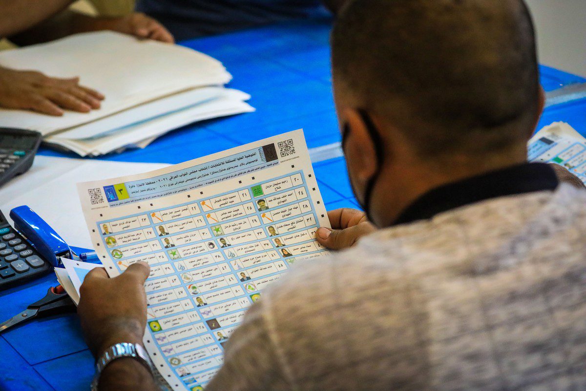 Funcionários da comissão eleitoral contam os votos após as eleições em Bagdá, Iraque, em 13 de outubro de 2021 [Murtadha Al-Sudani/Agência Anadolu]
