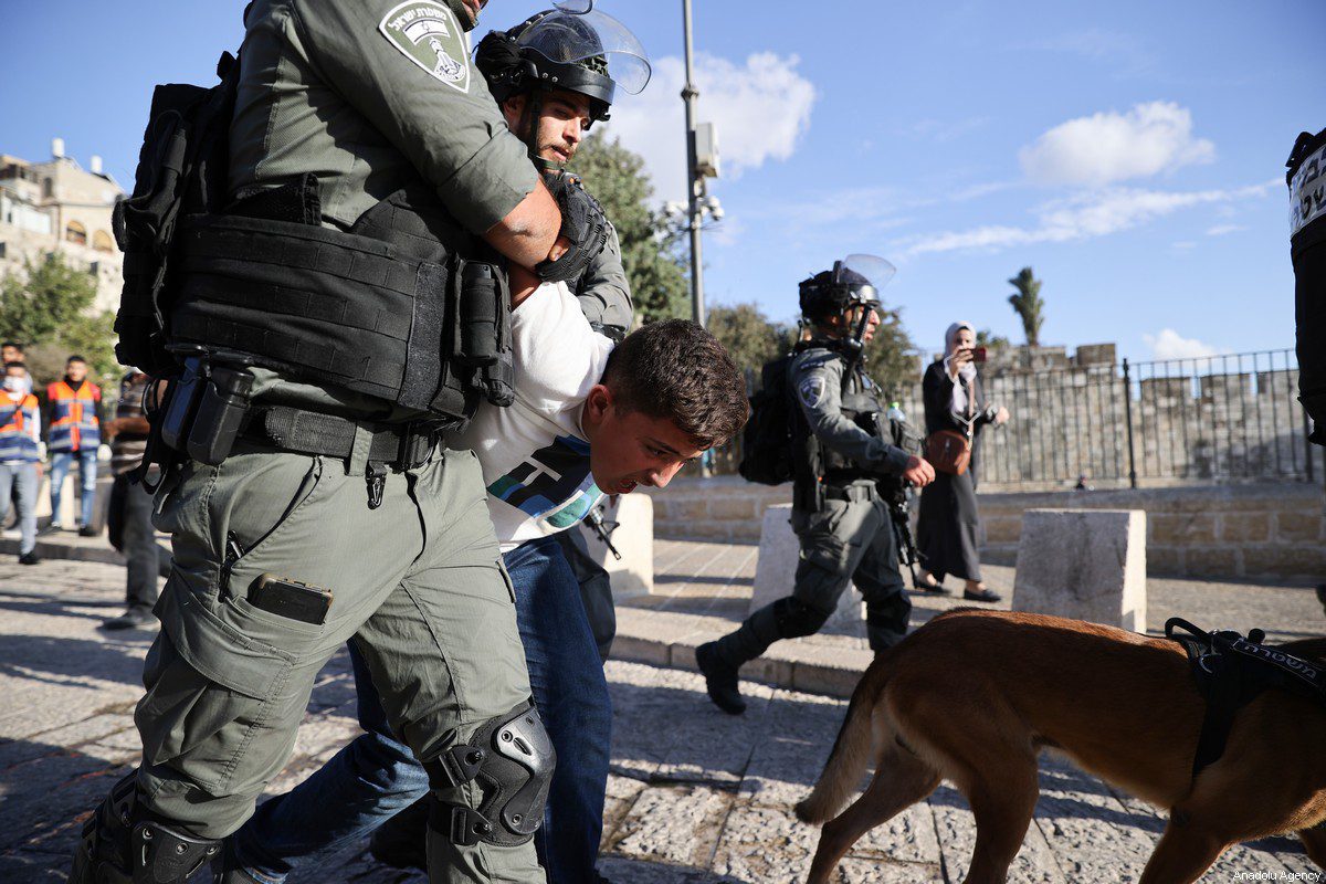 A polícia israelense prende um menino palestino, 19 de outubro de 2021 [Mostafa Alkharouf/Agência Anadolu]
