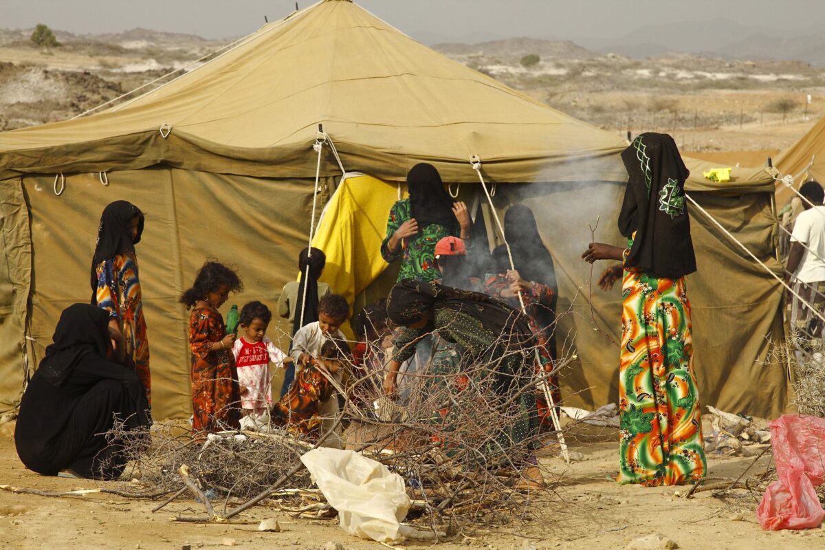 Mulheres e crianças iemenitas cuidam de um incêndio no campo de deslocados internos da ONU em Mazrak, norte do Iêmen. [Hugh Macleod / IRIN]