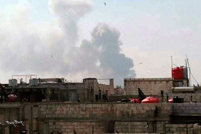 Fumaça sobre edifícios na cidade central de Homs, na Síria [SANA/AFP via Getty Images]

