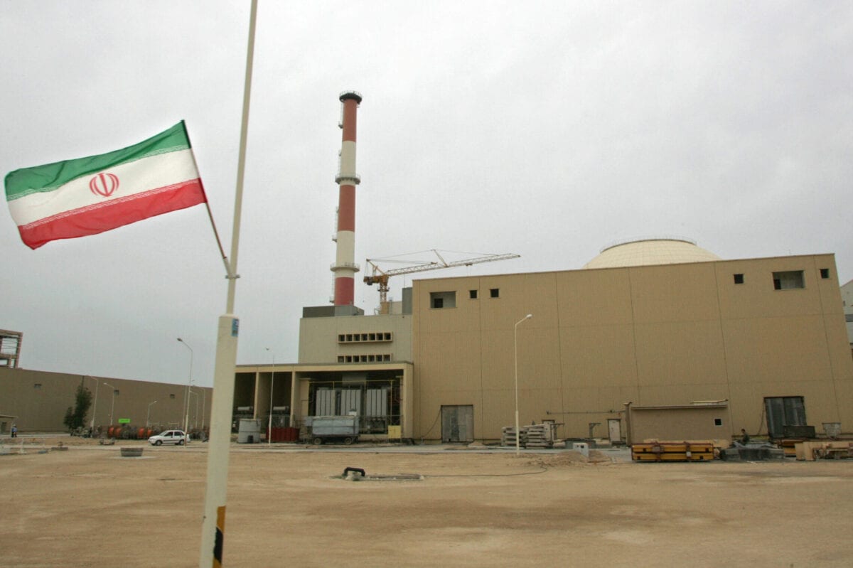 Bandeira iraniana em frente à usina nuclear de Bushehr, na cidade portuária de mesmo nome, no sul do Irã, 3 de abril de 2007 [BEHROUZ MEHRI/AFP FILES/AFP via Getty Images]
