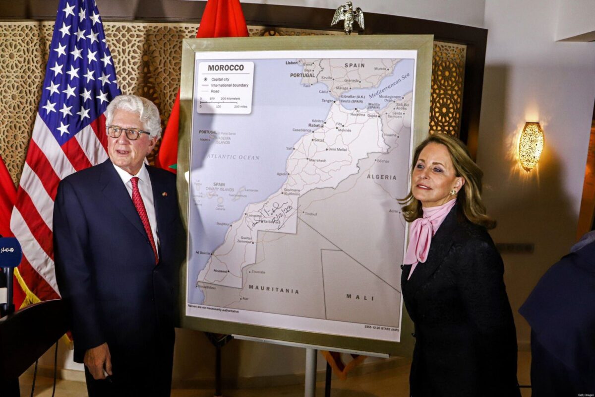 David T. Fischer (esq.), embaixador dos EUA no Reino de Marrocos, e sua esposa, Jennifer, diante de um mapa do Marrocos, reconhecendo o território internacionalmente disputado do Saara Ocidental como parte do reino do Norte da África, na capital do Marrocos, Rabat, em 12 de dezembro de 2020 [AFP via Getty Images]
