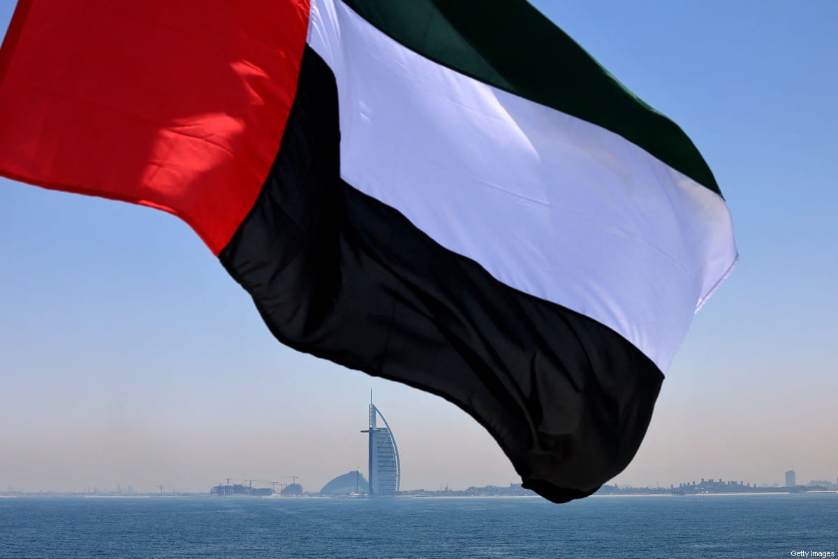 Bandeira dos Emirados tremulando acima da marina de Dubai com o hotel Burj Al Arab (centro) ao fundo, em 3 de junho de 2021 [Karim Sahib/AFP via Getty Images]
