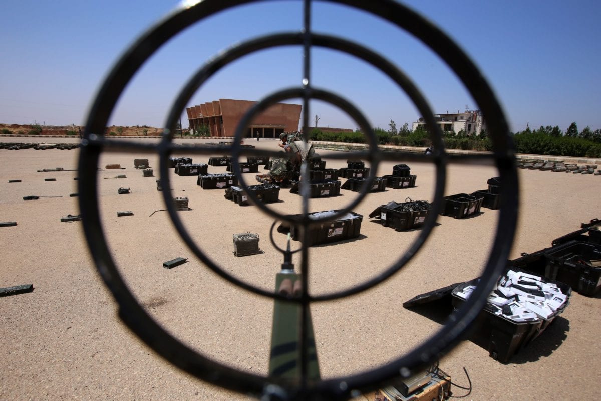 Soldados das forças do governo sírio exibem armas confiscadas das forças de oposição em uma base militar do exército sírio na cidade de Ezraa, província de Daraa, em 4 de julho de 2018 [YOUSSEF KARWASHAN/AFP/Getty Images]
