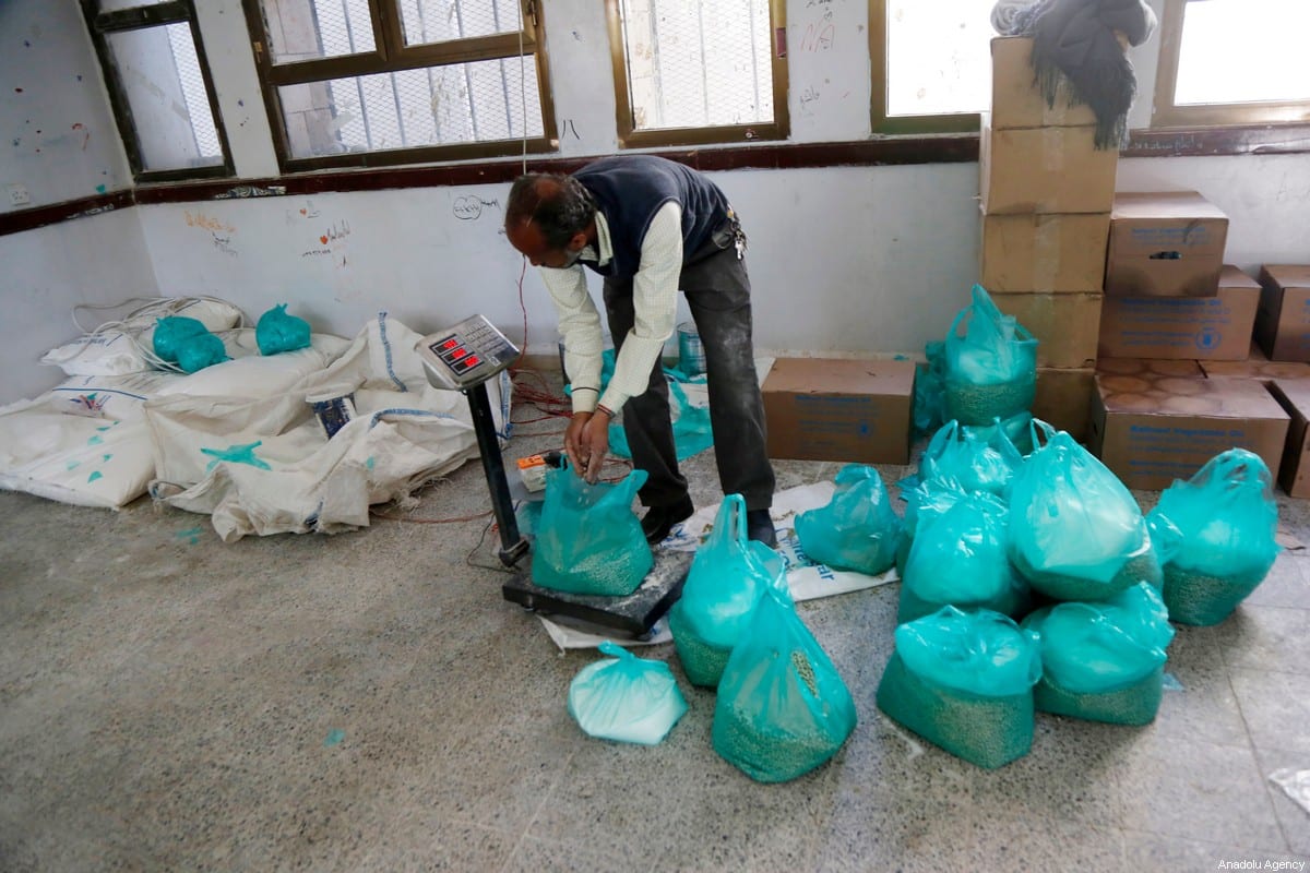 Os iemenitas recebem ajuda alimentar distribuída pelo Programa Mundial de Alimentos das Nações Unidas (PMA) em Sanaa, Iêmen, em 26 de janeiro de 2021 [Mohammed Hamoud/Agência Anadolu]
