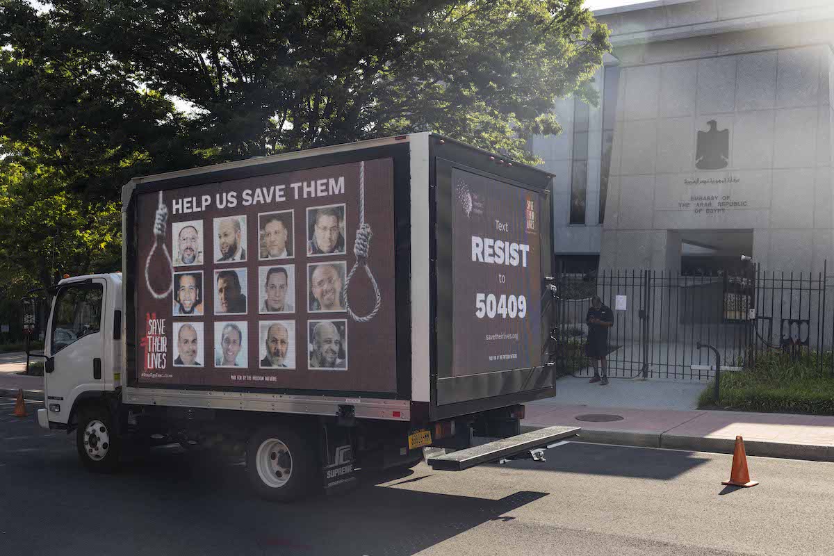 Um anúncio de caminhão, exibindo os rostos de 12 prisioneiros políticos no Egito que enfrentam a pena de morte, passou por Washington, EUA, em 17 de julho de 2021 [The Freedom Initiative/Flickr]
