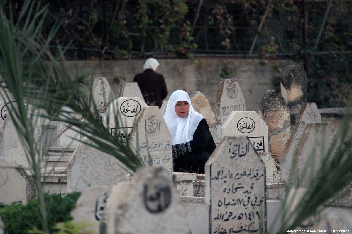Mulher palestina visita seus entes queridos em um cemitério na cidade de Nablus, Cisjordânia ocupada, em 15 de outubro de 2013 [Nedal Eshtayah/Apaimages]
