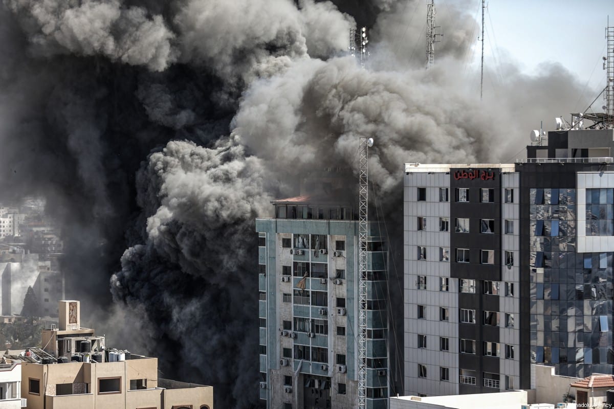 Fumaça após as forças israelenses destruirem prédio na cidade de Gaza, onde a Al-Jazeera e Associated Press tinham seus escritórios, em 15 de maio de 2021 [Ali Jadallah/Agência Anadolu]
