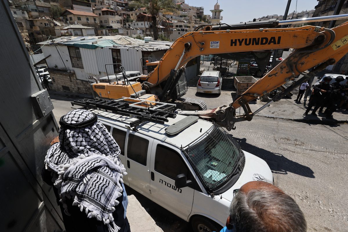 Bulldozers israelenses apoiados pelas forças policiais derrubam uma casa palestina na cidade de Silwan, em Jerusalém Oriental, em 10 de agosto de 2021 [Mostafa Alkharouf/Agência Anadolu]