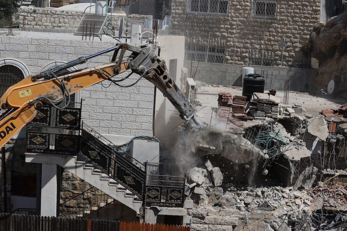 Tratores israelenses escoltados pela polícia destroem edifícios residenciais no bairro ocupado de Silwan, em Jerusalém Oriental, 10 de agosto de 2021 [Mostafa Alkharouf/Agência Anadolu]
