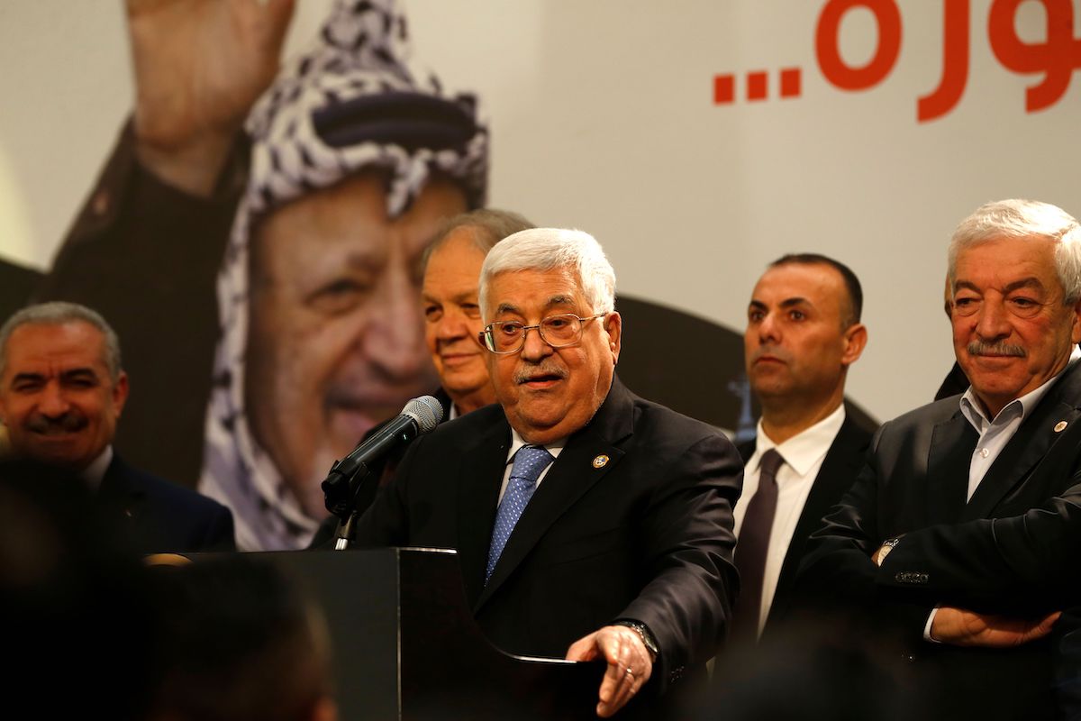 Presidente da Autoridade Palestina (AP) Mahmoud Abbas em frente a um retrato de Yasser Arafat, durante comemorações do 55° aniversário do partido Fatah, em Ramallah, Cisjordânia ocupada, 31 de dezembro de 2019 [ABBAS MOMANI/AFP via Getty Images]
