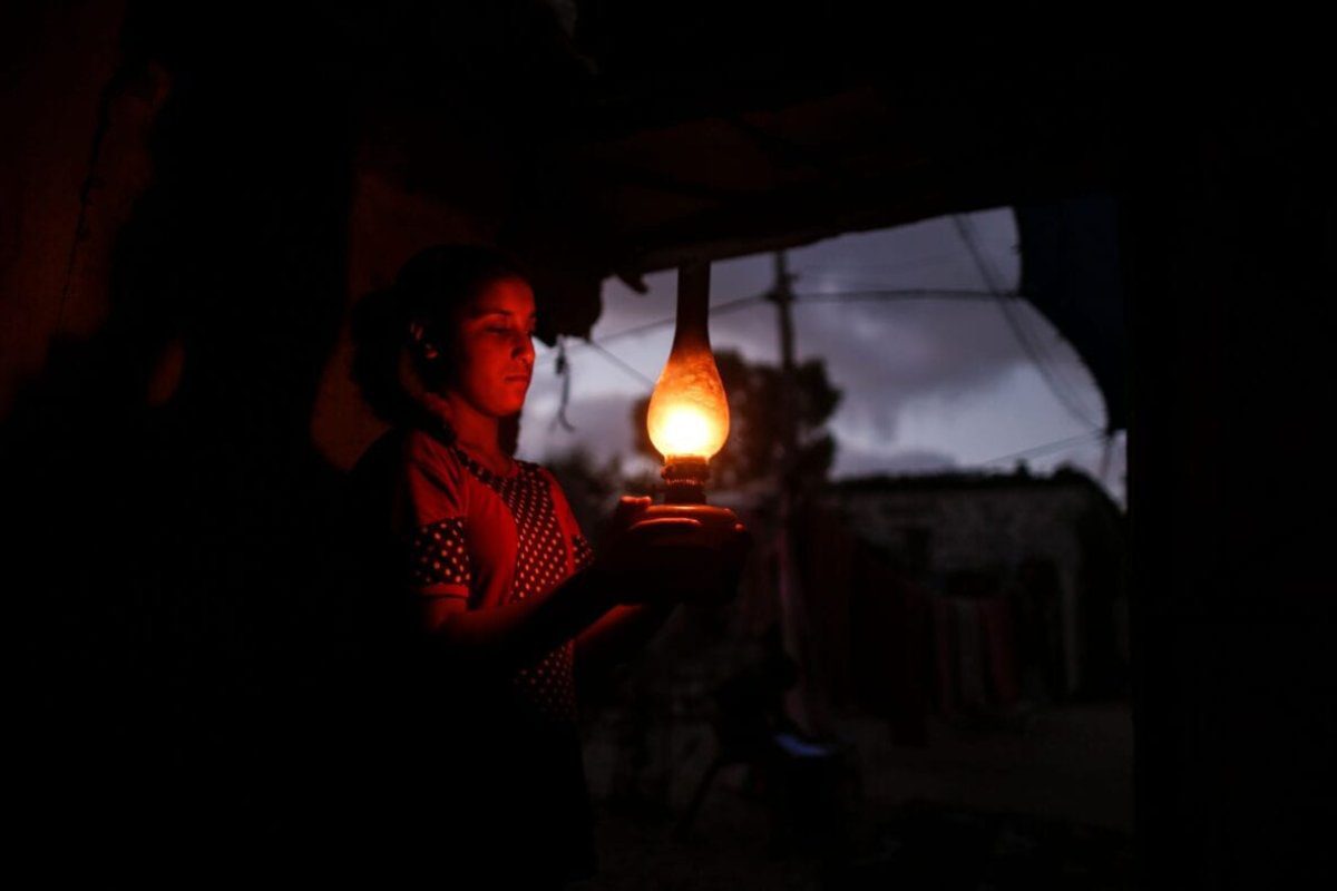 Palestina usa lamparina durante blecaute em Gaza, 18 de agosto de 2020 [MAHMUD HAMS/AFP via Getty Images]