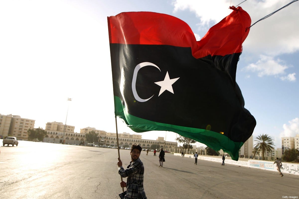 Um homem líbio agita sua bandeira nacional em Benghazi, Líbia, em 27 de fevereiro de 2015 [ABDULLAH DOMA/AFP/Getty Images]
