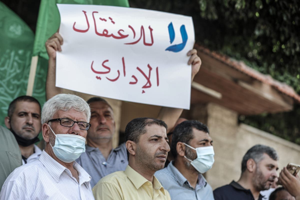 Palestinos seguram cartazes durante um protesto contra a política israelense de detenção administrativa em frente ao prédio do Comitê Internacional da Cruz Vermelha (CICV) na Cidade de Gaza, Gaza, em 12 de julho de 2021 [Ali Jadallah/Agência Anadolu]
