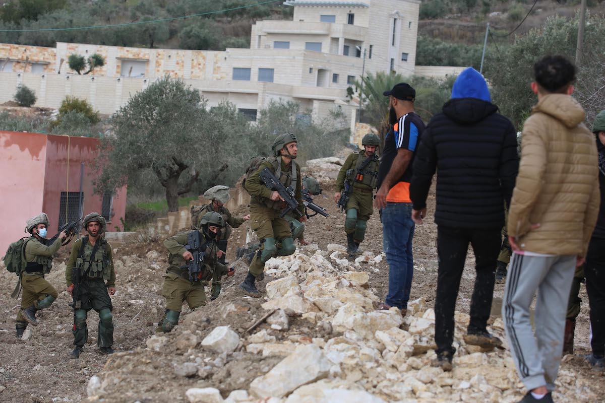 Forças israelenses acuam palestinos que protestam contra a invasão de colonos judeus em uma aldeia palestina perto da cidade de Nablus, Cisjordânia, em 17 de dezembro de 2021 [Nedal Eshtayah/Agência Anadolu]
