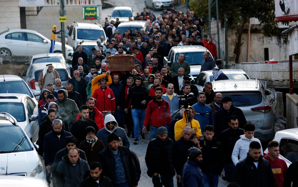 Pessoas carregam o corpo da palestina Ghadeer Masalmeh, que foi morta depois que um colonizador israelense a atropelou com seu veículo, durante seu funeral na cidade de Ramallah, na Cisjordânia, em 24 de dezembro de 2021. [Wajed Nobani/Apaimages].