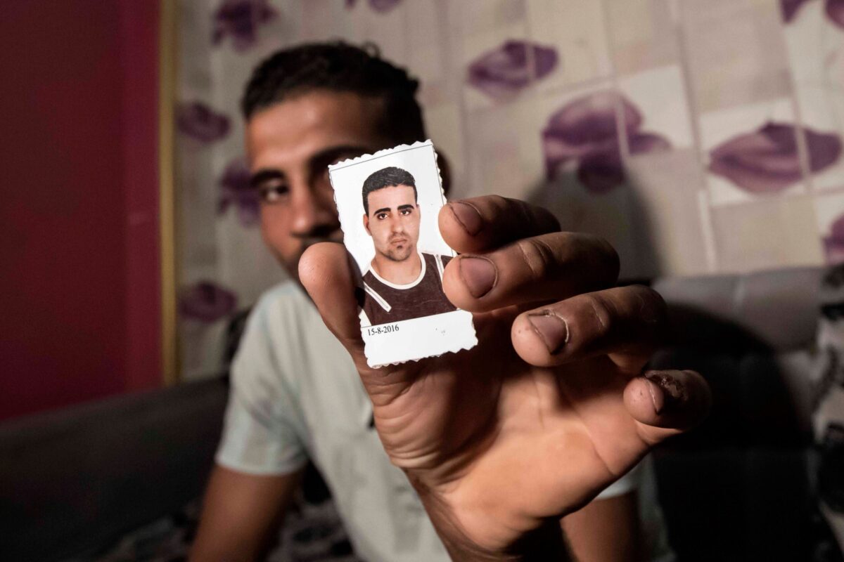 Cidadão egípcio Karim Farrag com um retrato de seu irmão Mohamed, um dos 17 egípcios desaparecidos na Líbia, em 23 de setembro de 2020 [KHALED DESOUKI/AFP via Getty Images]
