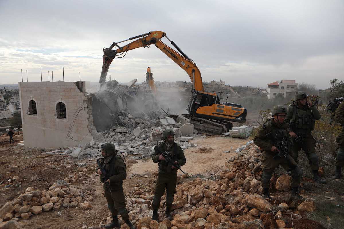 Forças israelenses demolem um prédio palestino na Cisjordânia, em 28 de dezembro de 2021 [Mamoun Wazwaz/Agência Anadolu]
