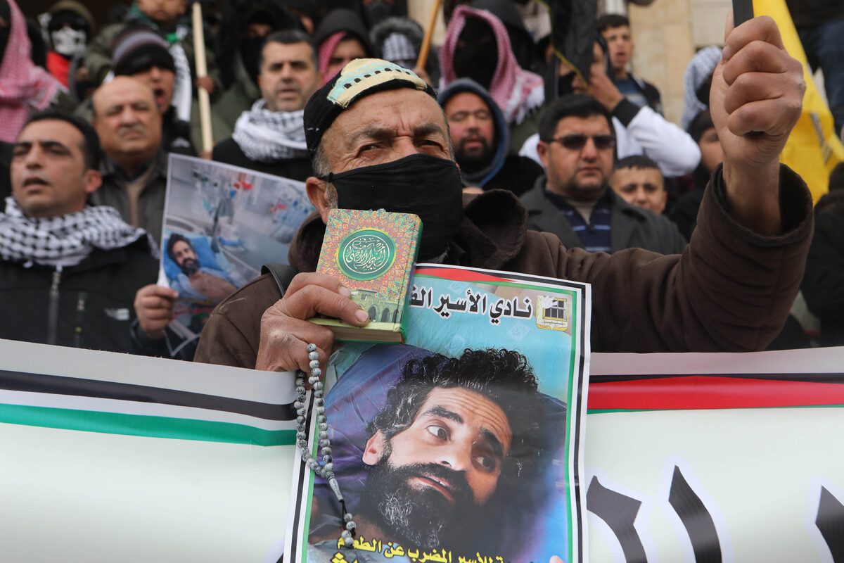 Pessoas participam de um protesto em solidariedade ao prisioneiro palestino Hisham Abu Hawash e outros palestinos detidos em Israel, no distrito de Dura, na cidade de Hebron, na Cisjordânia, em 04 de janeiro de 2022 [Mamoun Wazwaz/Agência Anadolu]
